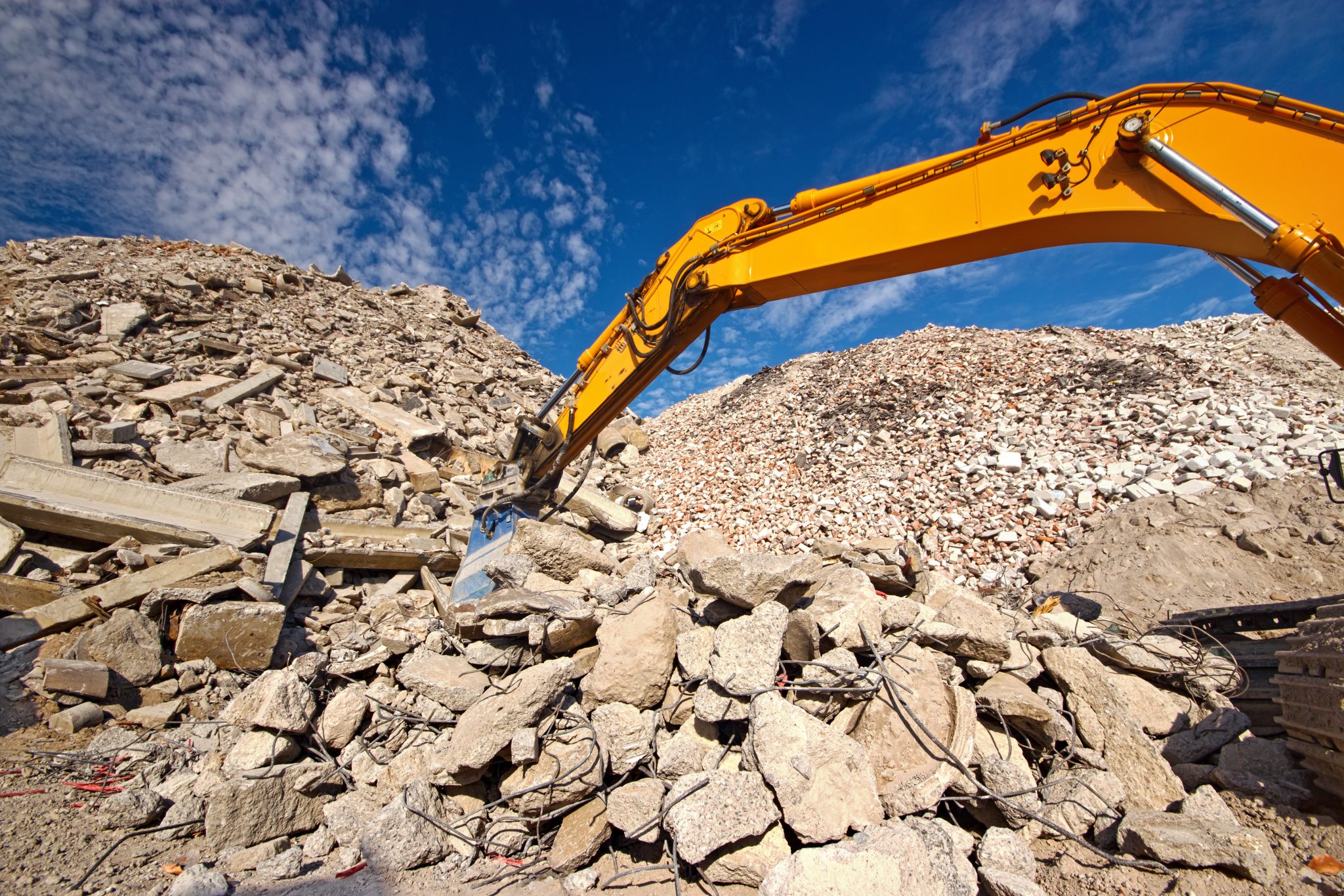 Construction and demolition (C&D) waste recycling site with excavator boom