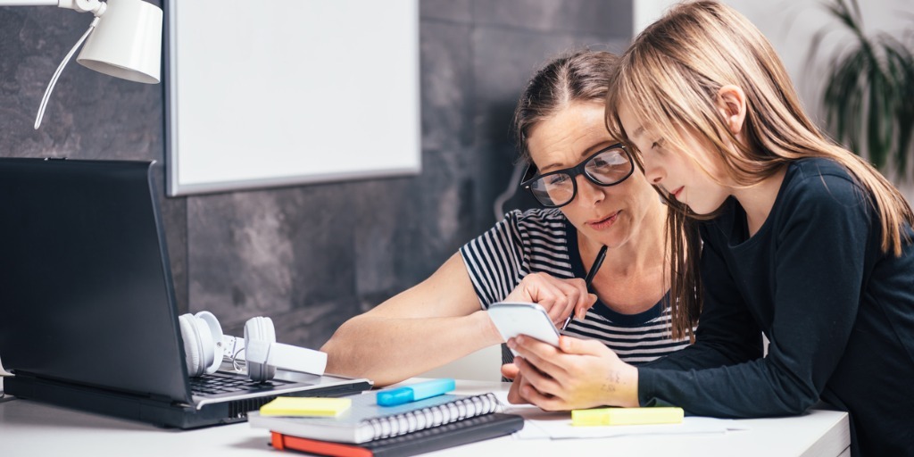 A mother and a daughter using a phone together