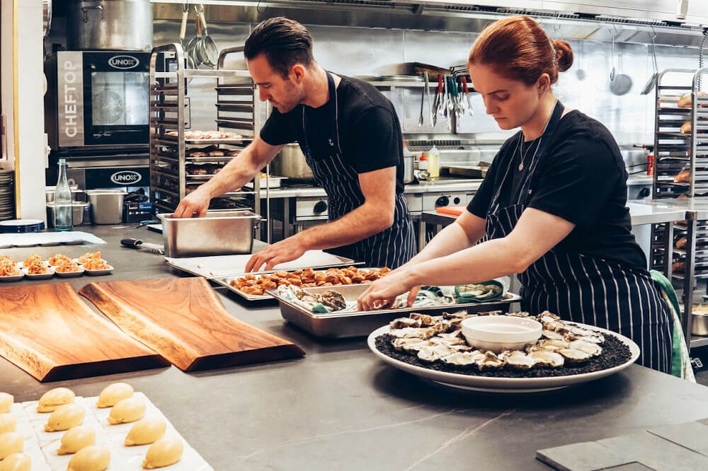 two workers in a restaurant kitchen