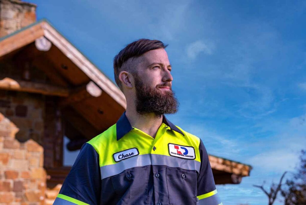 Texas Disposal Systems employee in front of a building and a blue sky.
