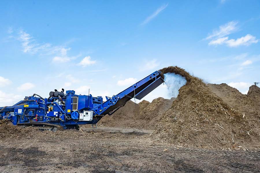TDS blue composting grinder grinding up branches and wood into mulch