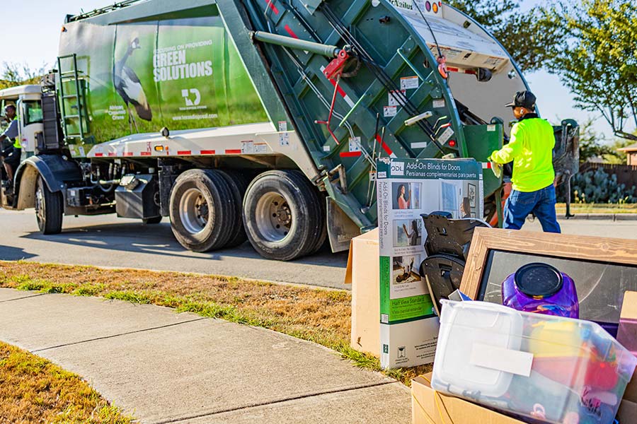 Bulky items in front of TDS green trash pick up truck