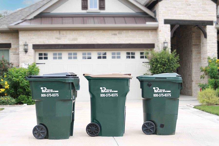 Green TDS trash compost recycling carts in front of house